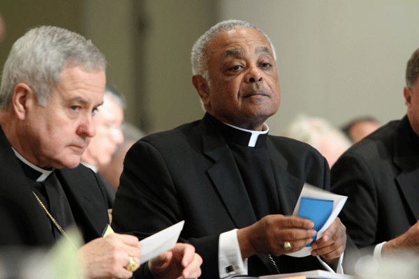 Archbishop Robert J. Carlson of St. Louis, left, and and Archbishop Wilton D. Gregory of Atlanta prepare to vote on an action item during the U.S. bishops' mid-year meeting in Atlanta June 13. (CNS photo/Michael Alexander, Georgia Bulletin) 