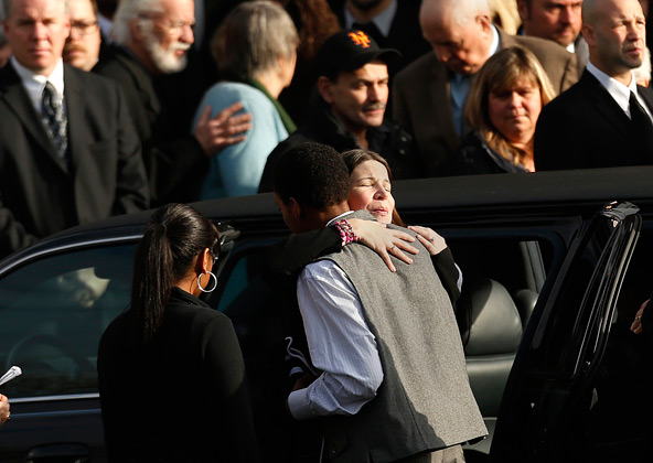 Krista Rekos, the mother of Sandy Hook Elementary school student Jessica Rekos, embraces a young man following Jessica's funeral Mass at St. Rose of Lima Church in Newtown, Conn., Dec. 18. Mourners packed back-to-back services at the church that day for Jessica and James Mattioli, two of the 20 young victims of the Newtown shooting massacre. (CNS photo/Shannon Stapleton, Reuters)