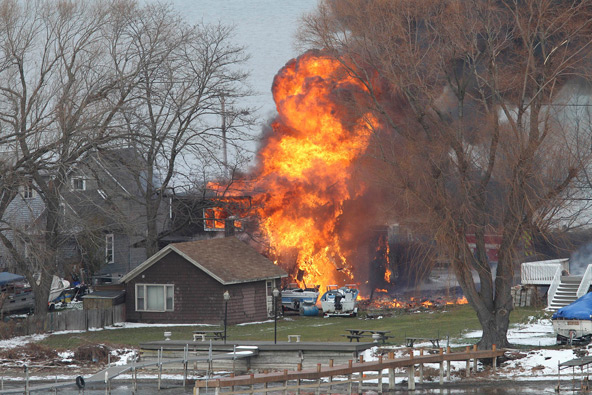 A house burns after police said 62-year-old William Spengler Jr. set it on fire, then killed two volunteer firefighters and injured two others when they responded in Webster, N.Y., Dec. 24. One of the dead firefighters, Tomasz Kaczowka, was a member of S t. Stanislaus Church in Rochester. (CNS photo/Jamie Germano, Democrat and Chronicle handout photo via Reuters) 