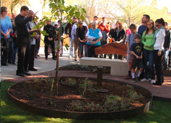 SOLT Father Brady Williams blessed the Griffin Eliot Gaspard memorial site at Most Holy Trinity Dec. 22 while his family stands beside a likeness of Griffin's footprint. (Ambria Hammel/CATHOLIC SUN)