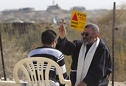 A Franciscan priest holds a cross as he hears confession from a young pilgrim during a ceremony at the baptismal site known as Qasr el-Yahud near the West Bank city of Jericho Jan. 13. It's the traditional site where John the Baptist is believed to have baptized Jesus. (CNS photo/Ronen Zvulun, Reuters)