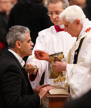 Pope Benedict XVI gives Communion to Miguel Diaz, then-U.S. ambassador to the Vatican, during a 2010 Mass in St. Peter's Basilica at the Vatican. Diaz, who stepped down in November after nearly four years as ambassador, said he and the pope bonded over t he fact they are both theologians. The 85-year-old pope announced Feb. 11 that he will resign at the end of the month. (CNS photo/Paul Haring)