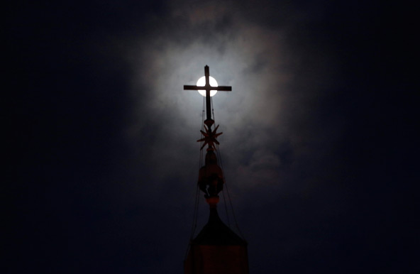A full moon is seen behind the cross of the Obelisk of St. Peter's Square at the Vatican Feb. 23, the eve of Pope Benedict XVI's final Angelus. (CNS photo/Eric Gaillard, Reuters) 
