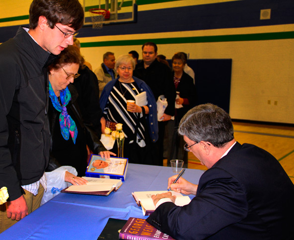 George Weigel signs his new book "Evangelical Catholic" after a Jan. 26 benefit for the John Paul II Resource Center. (Courtesy photo)