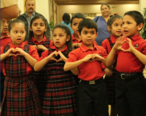 Some of St. John Vianney's kindergarteners and first-graders rehearse "Notre Dame Our Mother," the University of Notre Dame's alma mater Feb. 1 before performing it for their school's founder, Holy Cross Father Joe Corpora, and 200 supporters during a benefit dinner and auction at the Wigwam Resort in Litchfield Park. (Ambria Hammel/CATHOLIC SUN)