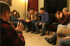 Local Catholics who knew Deacon Jim Mickens through his involvement in the Catholic Retreat for Young Singles group pray over him and his wife Janice as a sign of gratitude for their service and for a safe trip to their new home on the east coast. (Ambria Hammel/CATHOLIC SUN)