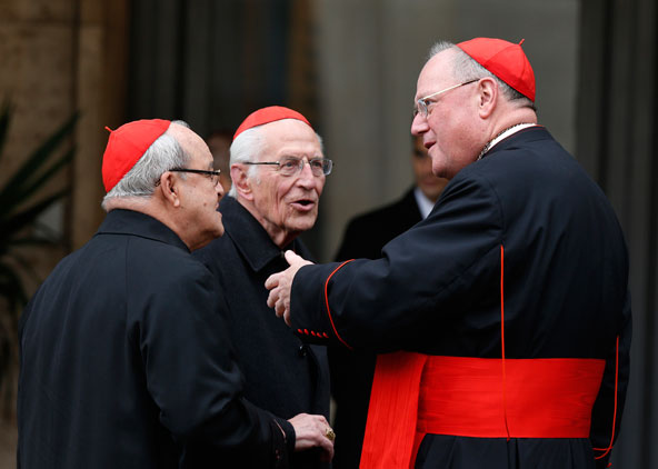 Cardinal Timothy M. Dolan of New York, right, talks with Cardinal Jaime Ortega of Havana, left, and an unidentified cardinal as they arrive for the fourth day of general congregation meetings in the synod hall at the Vatican March 7. (CNS photo/Paul Haring) 