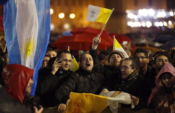 The flag of Argentina is seen as the crowd in St. Peter's Square reacts to white smoke billowing from the Sistine Chapel chimney March 13 at the Vatican. Argentine Cardinal Jorge Mario Bergoglio was elected the 266th Roman Catholic pontiff on the second day of the conclave. The Jesuit and first Latin American pope took the name Francis I. (CNS photo/Paul Haring)