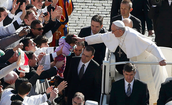 Pope Francis reaches out to bless a child as he arrives in St. Peter's Square before his inaugural Mass at the Vatican March 19. (CNS photo/Paul Hanna, Reuters)