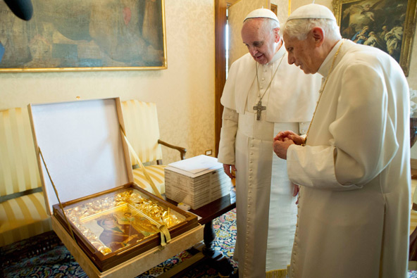 Pope Francis exchanges a gift with retired Pope Benedict XVI after arriving at the papal summer residence in Castel Gandolfo, Italy, March 23. Pope Francis traveled by helicopter from the Vatican to Castel Gandolfo for the private meeting with the former pontiff. (CNS photo/L'Osservatore Romano via Reuters)
