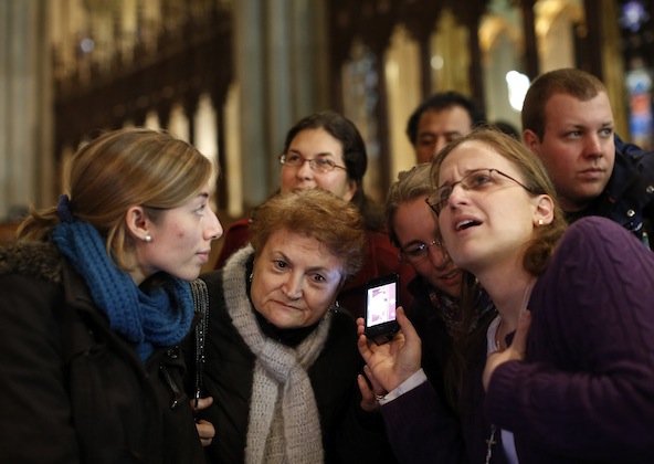 Valentina Bruner of Peru, left, and Florencia Silva of Trumbell, Conn., right, share a webcast of newly-elected Pope Francis, Cardinal Jorge Mario Bergoglio of Buenos Aires, Argentina, at St. Patrick's Cathedral in New York March 13. (CNS photo/Brendan McDermid, Reuters)