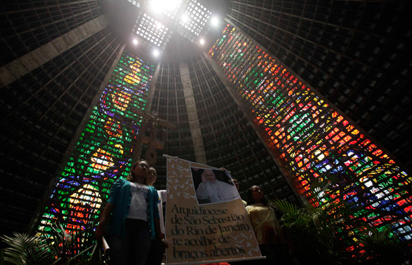 Youths hold up a banner with a message of welcome for Pope Francis during Palm Sunday Mass in Rio de Janeiro's cathedral March 24. The new pope will travel to Rio in July to take part in the international World Youth Day gathering. (CNS photo/Ricardo Mor aes, Reuters)
