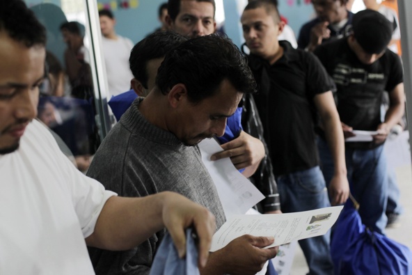 Deportees check immigration documents after they arrive in San Pedro Sula, Honduras, on an immigration flight from the United States in late March. As the U.S. Senate returns after break and tens of thousands plan a rally, Washington lawmakers focus on immigration reform. (CNS photo/Jorge Cabrera, Reuters)
