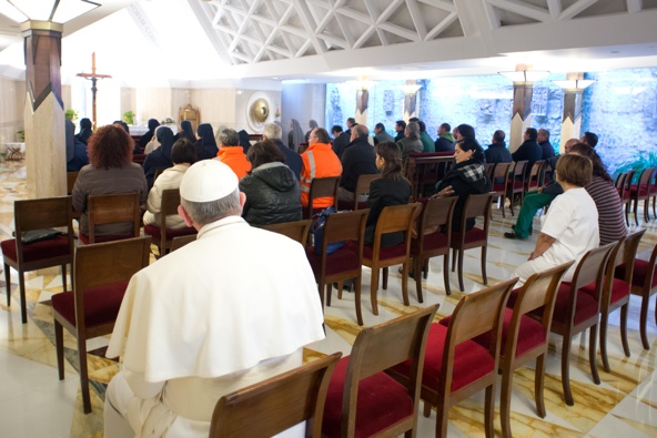 Pope Francis sits with Vatican workers after celebrating Mass March 22 inside the chapel of the Domus Sanctae Marthae, the Vatican residence where the new pontiff resides. The pope took a seat in the back row as people lingered for private prayer. (CNS photo/L'Ossevatore Romano)