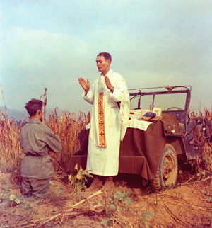 U.S. Army chaplain Father Emil Joseph Kapaun, who died May 23, 1951, in a North Korean prisoner of war camp, is pictured celebrating Mass from the hood of a jeep Oct. 7, 1950, in South Korea. He was captured about a month later. The Medal of Honor, the n ation's highest military award for bravery, will be awarded to the priest posthumously at the White House April 11. (CNS photo/courtesy U.S. Army medic Raymond Skeehan)