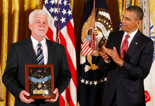 U.S. President Barack Obama presents the Medal of Honor to Ray Kapaun, who accepted it on behalf of his uncle, U.S. Army chaplain Father Emil Joseph Kapaun, at the White House in Washington April 11. The priest, who died May 23, 1951, in a North Korean p risoner of war camp, was honored with the nation's highest military award for bravery. (CNS photo/Larry Downing, Reuters)