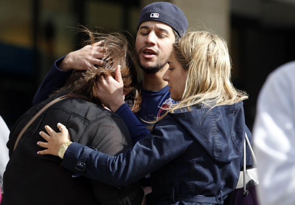 People comfort each other after explosions went off at the Boston Marathon April 15. Two bombs exploded in the crowded streets near the finish line of the marathon, killing at least three people, including an 8-year-old boy, and injuring more than 140. (CNS photo/Jessica Rinaldi, Reuters)