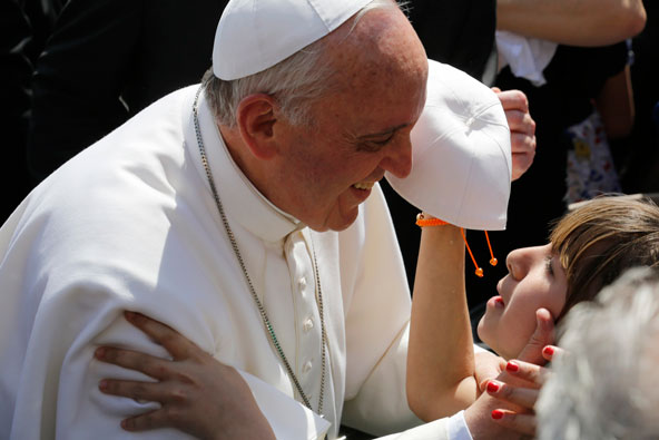 Pope Francis greets a girl who gives him a new skull cap as he arrives to lead his weekly audience in St. Peter's Square at the Vatican May 8. (CNS photo/Stefano Rellandini, Reuters)