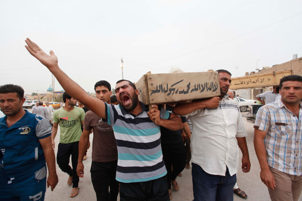 Relatives carry the coffin of an Iraqi police officer killed by militants, during a funeral in Najaf, Iraq, May 20. The patriarch of the Chaldean Catholic Church denounced a recent series of car bombings and shootings in Iraqi cities that left at least 5 4 people dead and dozens more injured. (CNS photo/Haider Ala , Reuters) 