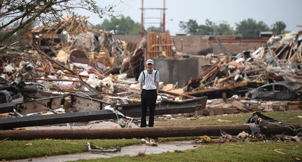 A man stands amid the wreckage left by a tornado that struck Moore, Okla., May 20. The tornado touched down outside Oklahoma City leaving a 20-mile path of death and destruction. (CNS photo/Gene Blevins , Reuters)