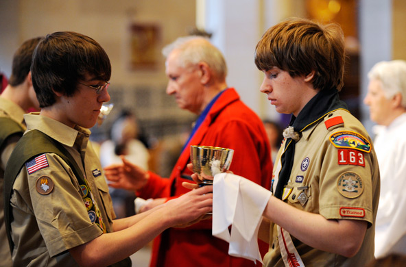 Boy Scouts serve as extraordinary ministers of holy Communion during a Catholic Scouting recognition Mass in 2010 at Sacred Heart Cathedral in Rochester, N.Y. The Boy Scouts of America voted May 23 to lift a ban on accepting openly gay Scouts as members, capping weeks of intense lobbying on both sides of the issue, the group said in a statement. (CNS photo/Mike Crupi, Catholic Courier)