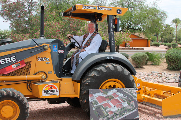 Fr. Patrick Robinson, pastor, poses on construction equipment during a May 5 groundbreaking to build and refresh Blessed Sacrament Parish in Scottsdale.  (Ambria Hammel/CATHOLIC SUN)