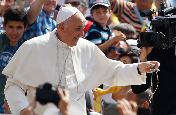 Pope Francis holds a rosary he caught in the crowd as he arrives for his weekly general audience in St. Peter's Square at the Vatican June 5. (CNS photo/Paul Haring)