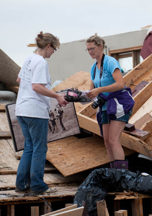 Monica Becker, right, sorts through belongings at her destroyed house near Corning, Kan., May 29. She was eager to comb the house and nearby fields for papers and photographs that day after a tornado struck the rural area north of Kansas City. Despite th e property losses, the Becker family expressed gratitude that they came out of the basement unharmed and for the help and support of friends. (CNS photo/Jessica Langdon, The Leaven)