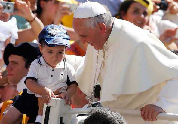 Pope Francis greets a young boy as he arrives to lead his general audience in St. Peter's Square at the Vatican June 19. (CNS photo/Paul Haring)
