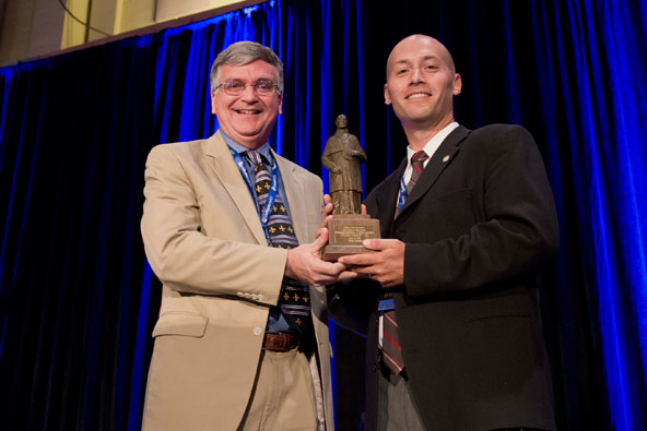 Peter Finney Jr., executive editor and general manager of the Clarion Herald newspaper of the Archdiocese New Orleans, accepts the St. Francis de Sales Award from Rob DeFrancesco of the Catholic Press Association of the United States and Canada June 21 a t the 2013 Catholic Media Conference in Denver. The award recognizing excellence in journalism is the highest honor given by the association. In remarks, Finney said he was humbled and honored and accepted the award on behalf of the staffs of the Clarion Herald and other Catholic newspapers in Louisiana and Mississippi. (CNS photo/Jeffrey Bruno)