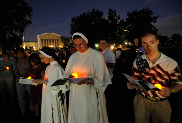 The U.S. Supreme Court is seen in the background as nuns and others pray during a candlelight vigil for the second annual Fortnight for Freedom observance outside the U.S. Capitol in Washington June 22. The campaign, initiated by the U.S. bishops in 2012 , calls for a two-week period of prayer, education and action on preserving religious freedom in the U.S. The observance ends July 4, Independence Day. (CNS photo/Leslie E. Kossoff)