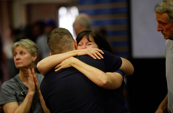 A family member of one of the 19 firefighters who perished battling a fast-moving Arizona wildfire is embraced during a memorial service in Prescott, Ariz., July 1. The Yarnell fire killed 19 of 20 members of the Granite Mountain Hotshot Crew, who ranged in age from 21 to 43 years old. (CNS Joshua Lott, Reuters)