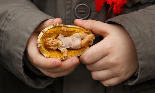 "Jesus, the Son of God, is the one who makes God known to us," says the encyclical "Lumen Fidei" ("The Light of Faith") from Pope Francis. Pictured is a child holding a figurine of the baby Jesus. (CNS file photo/Paul Haring) 