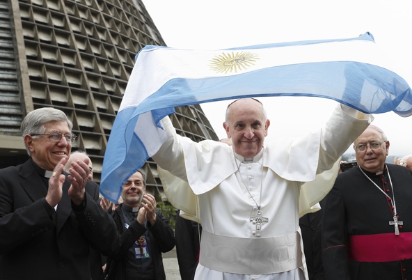 Pope Francis holds up Argentina's flag as he greets a crowd of World Youth Day pilgrims outside the cathedral in Rio de Janeiro July 25. (CNS photo/Paul Haring)