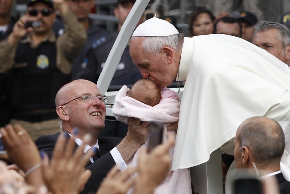 Pope Francis kisses a baby as he arrives at the archbishop's palace in Rio de Janeiro July 26. (CNS photo/Paul Haring)