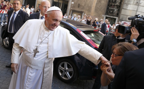 A woman kisses Pope Francis' hand as he arrives to celebrate a private Mass at the Church of the Gesu in Rome July 31. (CNS photo/Paul Haring)