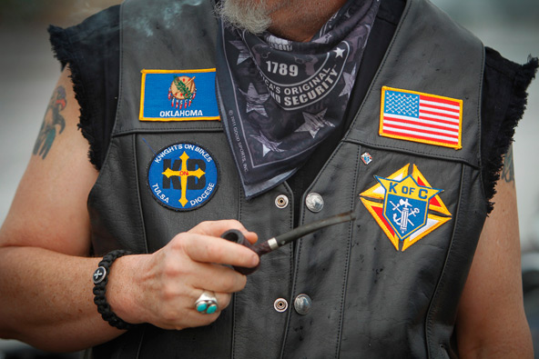 Charlie Hoy, a member of the Knights on Bikes from the Diocese of Tulsa, Okla., proudly displays patches on his vest in Tulsa in May. Knights on Bikes are a motorcycle ministry dedicated to improving the image of bikers and promoting safety and Christian values. (CNS photo/Dave Crenshaw, Eastern Oklahoma Catholic)