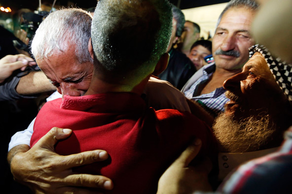 A relative greets a freed Palestinian prisoner (back facing camera) as he arrives in Ramallah, West Bank, early Aug.14. Later that day Palestinians and Israelis were to hold their first formal peace talks in the Mideast in nearly five years. (CNS photo/Mohamad Torokman, Reuters) 