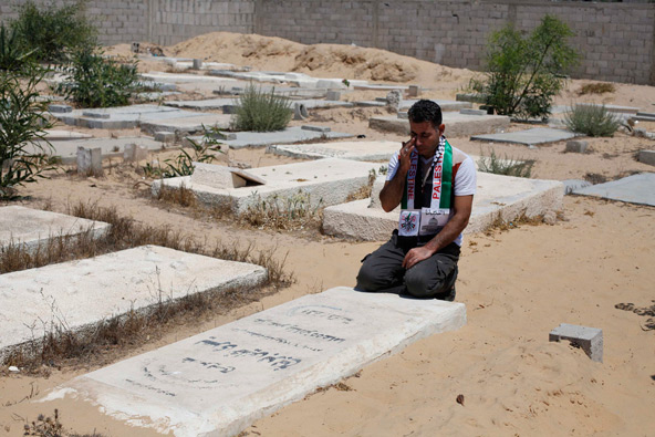 Freed Palestinian prisoner Midhat Barbakh mourns near the grave of his mother at a cemetery in Khan Younis in the southern Gaza Strip Aug. 14. That day Palestinians and Israelis were to hold their first formal peace talks in the Mideast in nearly five years. (CNS photo/Ibraheem Abu Mustafa, Reuters) 