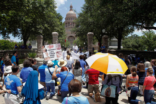 Catholics pray outside the state Capitol in Austin this summer as Texas legislators considered measures restricting abortion. The law prohibiting abortions after 20 weeks of pregnancy was signed by Gov. Rick Perry July 17. (CNS photo/Reuters)