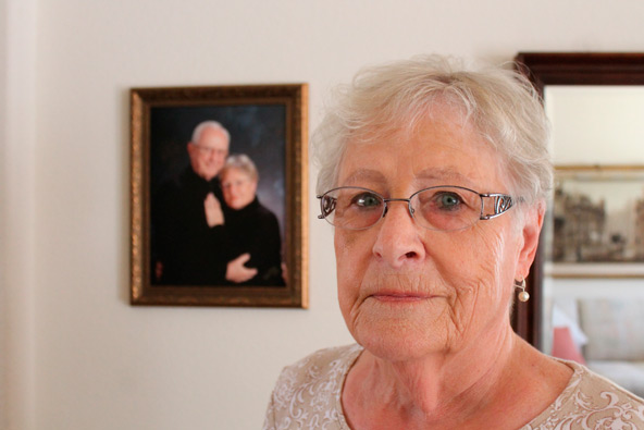 Barbara Bourgeois stands in front of a portrait of Lee, her deceased husband, and herself. Lee received hospice services from Americare prior to his death last year. (J.D. Long-Garcia/CATHOLIC SUN)