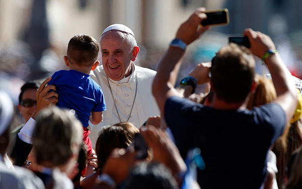 Pope Francis greets a child as he arrives to lead his weekly audience in St. Peter's Square at the Vatican Sept. 4. (CNS photo/Tony Gentile, Reuters)