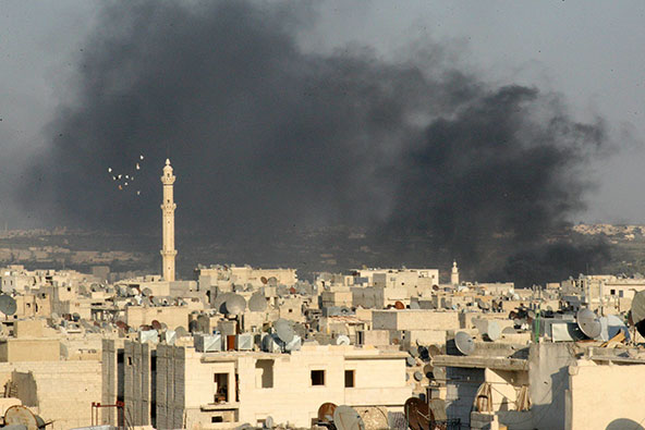 Smoke rises amid buildings in Aleppo, Syria, Sept. 4. Even with just war theory as a guide, analysts say the answers remain murky to moral and ethical questions about whether a military strike is the appropriate response to what U.S. officials believe was a chemical weapons attack on Syrian civilians. (CNS photo/Ammar Abdulla, Reuters) 