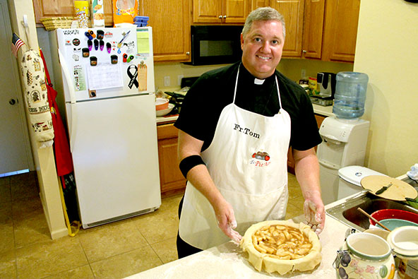 Holy Cross Father Tom Eckert shows off his pie-making skills that helped grow the student scholarship fund and enrollment at St. John Vianney Catholic School in Goodyear. (Ambria Hammel/CATHOLIC SUN)