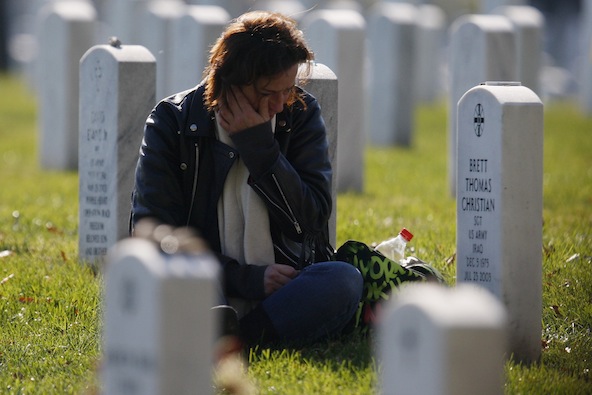 A woman grieves at a grave in Section 60, an area where members of the U.S. military who were killed in action in Iraq and Afghanistan are buried, during Veterans Day observances at Arlington National Cemetery in Arlington, Va., Nov. 11. (CNS photo/Jonathan Ernst, Reuters)