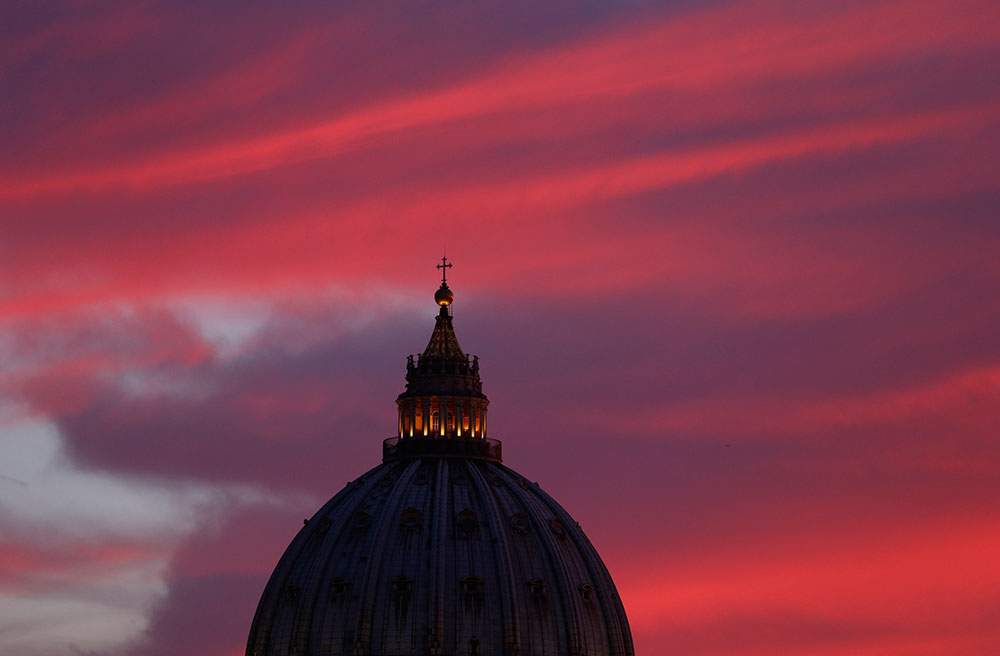 The sun colors the sky over the dome of St. Peter's Basilica during sunset at the Vatican Sept. 9. (CNS photo/Paul Haring) 