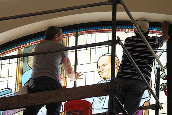 Workers put the finishing touches on the installation of the new Blessed John Paul II stained glass window, Sept. 27 in the Virginia G. Piper Chapel at the Diocesan Pastoral Center. (Ambria Hammel/CATHOLIC SUN)