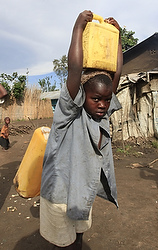 A boy carries water at a camp for internally displaced people in Kiwanja township in the rebel controlled territory in the eastern Congo Oct. 24. Fighting over the control of natural resources has led to the displacement of 260,000 Congolese, according to aid agencies. (CNS photo/James Akena, Reuters)