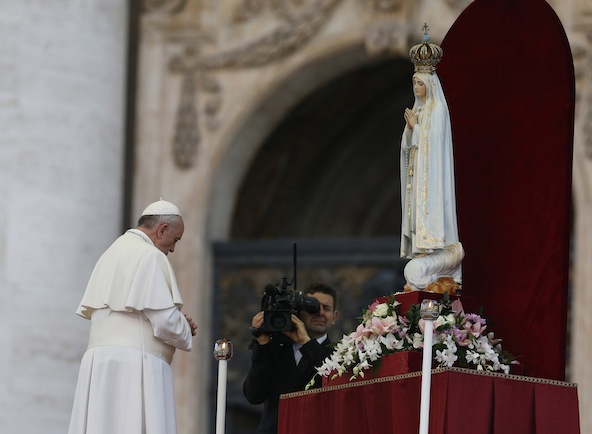 Pope Francis prays in front of the original statue of Our Lady of Fatima during a Marian vigil in St. Peter's Square at the Vatican Oct. 12. The statue was brought from Portugal for a weekend of Marian events culminating in Pope Francis entrusting the world to Mary. (CNS photo/Paul Haring)