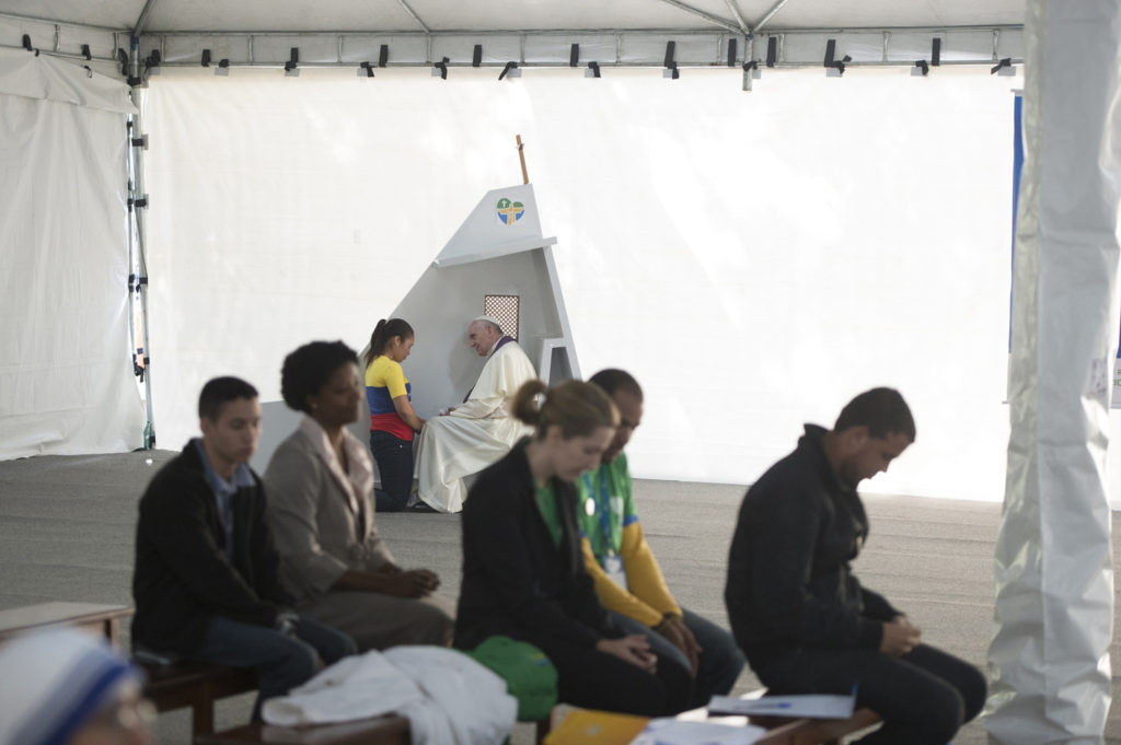 Pope Francis hears the confession of a young woman during World Youth Day in Rio de Janeiro July 26. Portable confessionals were set out in several public places for pilgrims attending World Youth Day. Five young people had the opportunity to take part in the sacrament of reconciliation with Pope Francis. (CNS photo/L'Osservatore Romano)